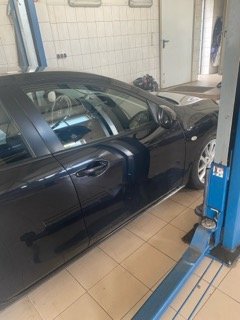 Samochód osobowy na podnośniku w warsztacie Grupa AVD, przygotowany do naprawy